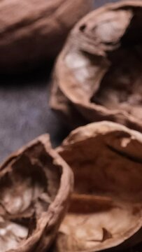 primo piano di gusci di noce e noci sul tavolo, con noci sgusciate, video verticale