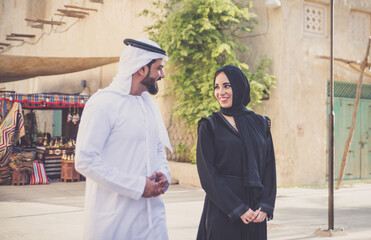 Happy couple spending time in Dubai. man and woman wearing traditional clothes making shopping in the old city