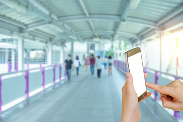 Woman using mobile smart phone with blurry walkway background