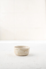 a small ceramic sauce pan on a white background with a place for text. Japanese style. Wabi-sabi.