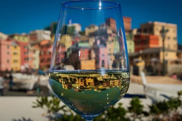 Fotobehang A glass of Vermentino Wine in front of Boccadasse, the pitoresque fishermen village nearby Genoa.  © Hari Seldon Photo