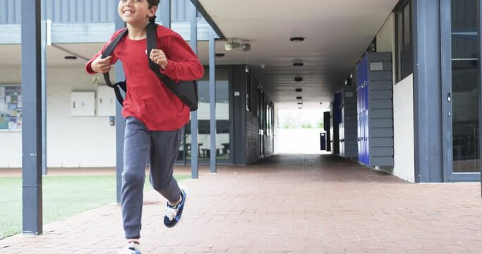 In a school corridor, a young student is running with copy space