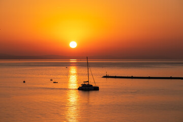 Sunset sail unfurls along the idyllic Omis Riviera, Adriatic Mediterranean Sea. Dramatic hues paint...
