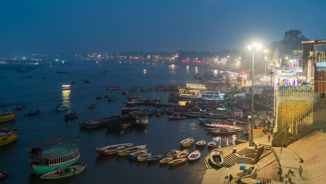 Day to night timelapse view of boats on the sacred Ganges river in Varanasi, Uttar Pradesh, India. 