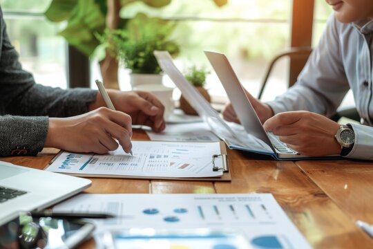 A diverse group of individuals sitting at a table, engrossed in their work as they use their laptops, Business associates negotiating business loan interest rates, AI Generated