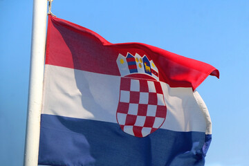 Flag of Croatia, blowing in the wind. Bright blue sky in the background. Selective focus.
