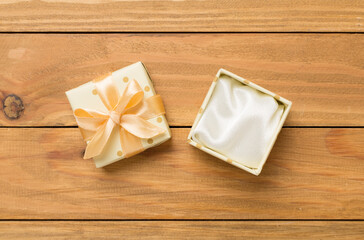Beige open gift box on wooden background, top view