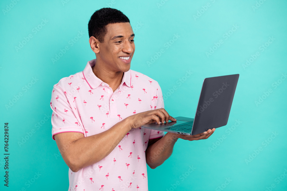 Poster photo of positive it specialist toothy smile use wireless netbook networking isolated on teal color 