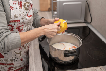 Woman Zesting Lemon into Pot on Stove