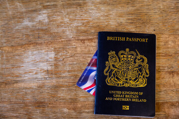 New British passport of post-Brexit blue black UK passport cover with against wooden background...
