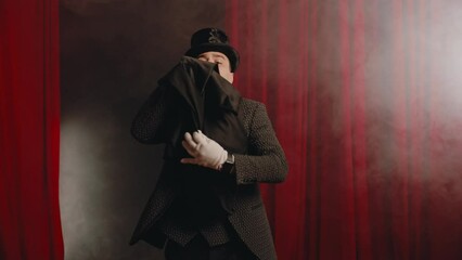 Elegant mysterious illusionist showing tricks with rabbit