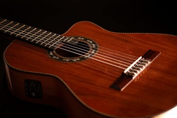 Classical Spanish flamenco guitar close up, dramatically lit isolated on black background with copy space.