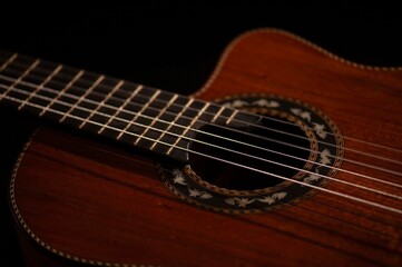 Classical Spanish flamenco guitar close up, dramatically lit isolated on black background with copy space.