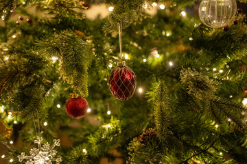 Low light Christmas decorations on Christmas tree creating a high end lifestyle look. Fairy lights and baubles.
