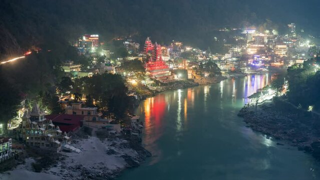 Dusk to night timelapse view of Hindu temples on the banks of the sacred Ganges river in Rishikesh, Uttarakhand, India.	