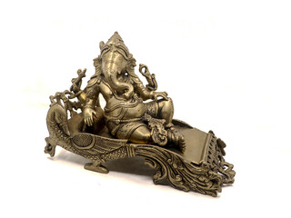 antique golden statue of elephant headed god lord ganesh sitting on a peacock throne isolated in a...