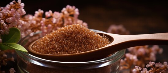 Spoon with brown sugar and flowers - obrazy, fototapety, plakaty