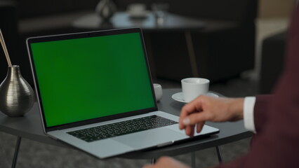 Unrecognizable businessman working green screen laptop. Employee typing keyboard