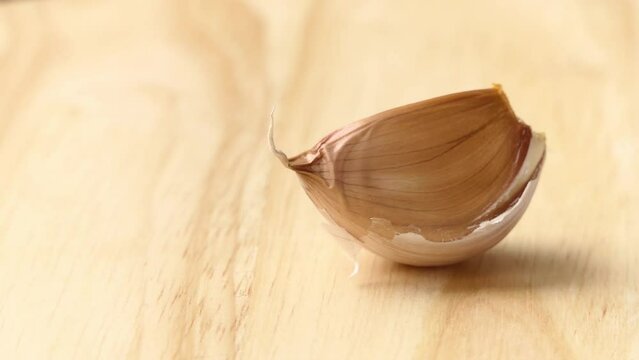 clove of garlic lies on wooden board