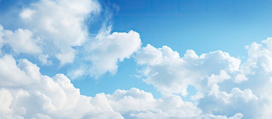 Naklejka na ściany i meble Fluffy clouds on a blue sky background