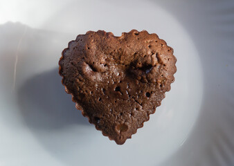 Chocolate cupcake in the shape of a heart on a plate