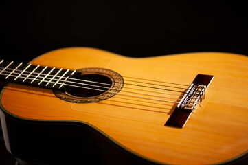 Classical Spanish flamenco guitar close up, dramatically lit isolated on black background with copy...