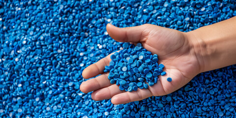 Hand Holding Blue Plastic Resin Pellets for Plastic Manufacturing, Overmolding, Low Pressure Overmolding, and Injection Molding Materials