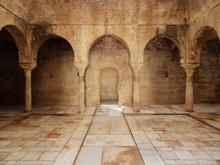 Fototapeta premium Interior view of the Arabic Baths El Banuelo, in Granada Spain. Sunlight entering the ceiling. Old and historic interior of Arab baths. Moorish architecture.