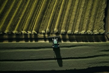 Aerial view of a Tractor fertilizing a cultivated agricultural field. Taking care of the Crop.