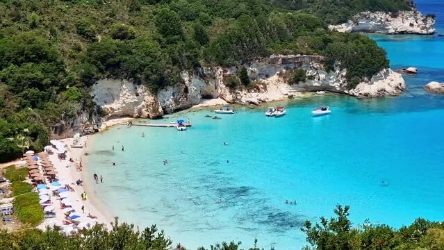 Greece Antipaxos island Voutoumi beach 4k. Turquoise exotic water like Maldives or Caribbean. Beautiful empty white sand beach with sailing boats. Ionian sea travel scenery summer vacation