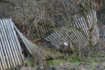 Destroyed fallen wooden fence in the countryside