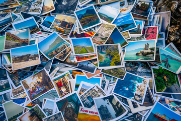 Fototapeta na wymiar A heap of printed travel photographs strewn on the ground, echoing memories and the wanderlust spirit. Lost or forgotten memories concept