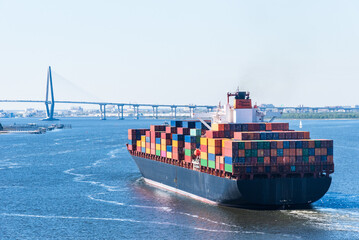 View on the container ship sailing through the river on her departure from port of Charleston, SC.