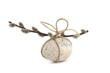 Oval pebble and catkin twig tied with string isolated on white background. Easter concept with egg...