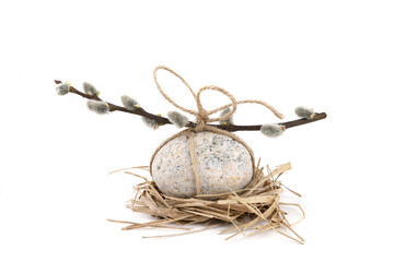 Oval pebble and catkin twig tied with string isolated on white background. Easter concept with egg...