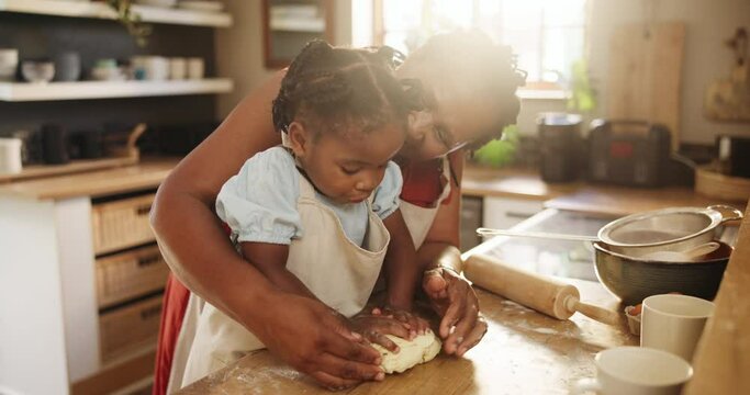 African, mom and baking with kid in kitchen and learning together in home and press dough on table in morning. Mother, teaching and child helping with cooking or prepare bread, mixture and breakfast