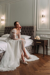 The image depicts a person wearing a wedding dress sitting on a couch indoors 6531.