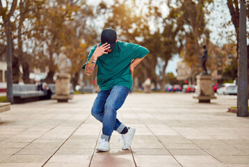 latin American breakdancer performing foot movements or toprock on the street	 - obrazy, fototapety, plakaty