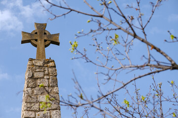 A cross stands tall on top of a weathered stone tower, symbolizing faith and strength.