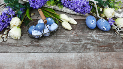 Ostereier mit Blumen  auf Holzhintergrund mit Textfreiraum.