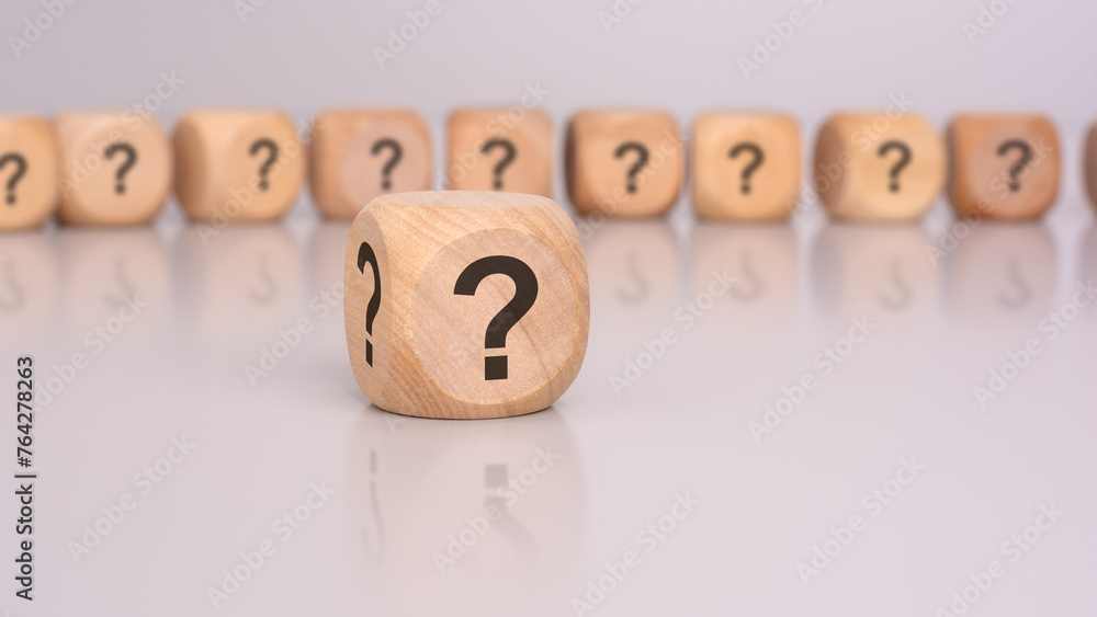 Aufkleber in the foreground is one wooden cube with a question mark and a reflection from the table surface. i
