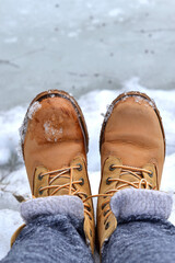 Feet in boots close-up against a background of snow