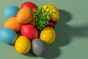 Colorful eggs, symbolizing Easter, on a colorful background and flowers