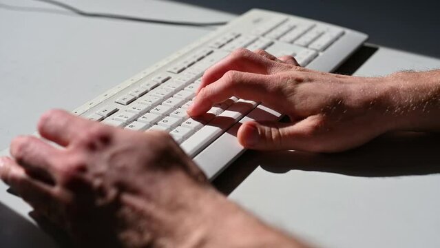 Zwei Männerhände schreiben schnell auf einer Computertastatur