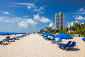 Beautiful view of the sandy beach of Miami Beach Atlantic Ocean with sun loungers and sun...