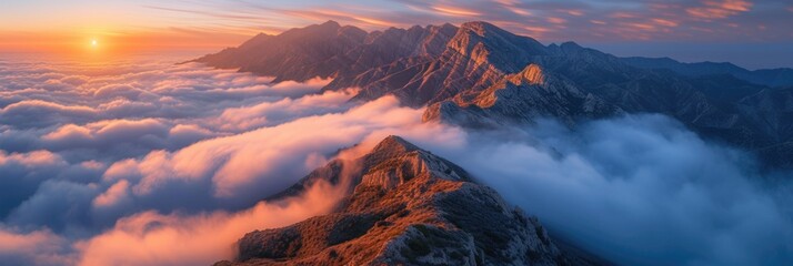 Naklejka premium Sunrise Over Mountain Peaks Above a Sea of Clouds