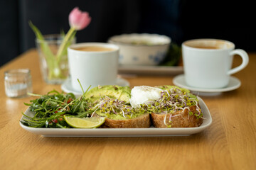 Bread Toast and Poached Egg with Green Salad and Avocado. Breakfast concept. Morning time. Avocado egg sandwich with whole grain bread