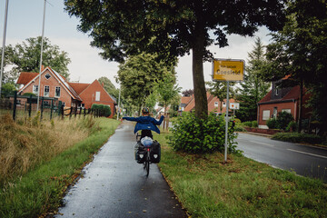 Junge passiert in Siegerpose mit seinem Rad das Ortsschild Coesfeld während einer Radreise durch das Münsterland, Kreis Coesfeld, Baumberge