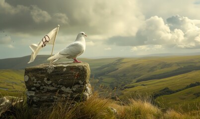 White pigeon standing on a stone pedestal with a peace flag waving in the breeze behind it against a backdrop of rolling hills - Powered by Adobe