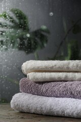 Stacked terry towels on table in bathroom - obrazy, fototapety, plakaty